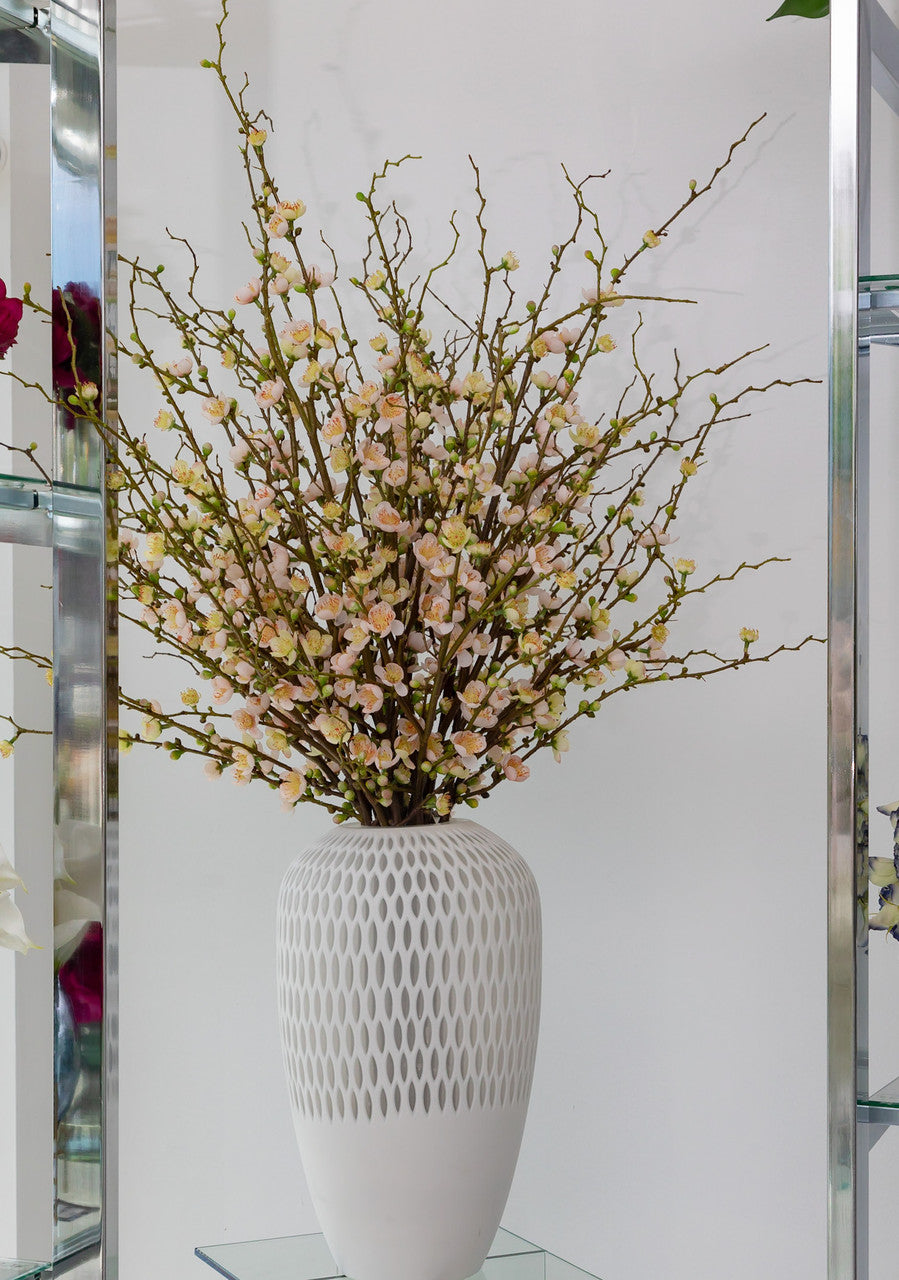 Fleurs de cerisier roses dans un vase Pélican