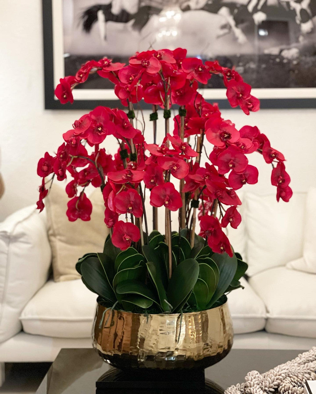 Composition florale d'orchidées Phalaenopsis rouges dans un grand pot doré