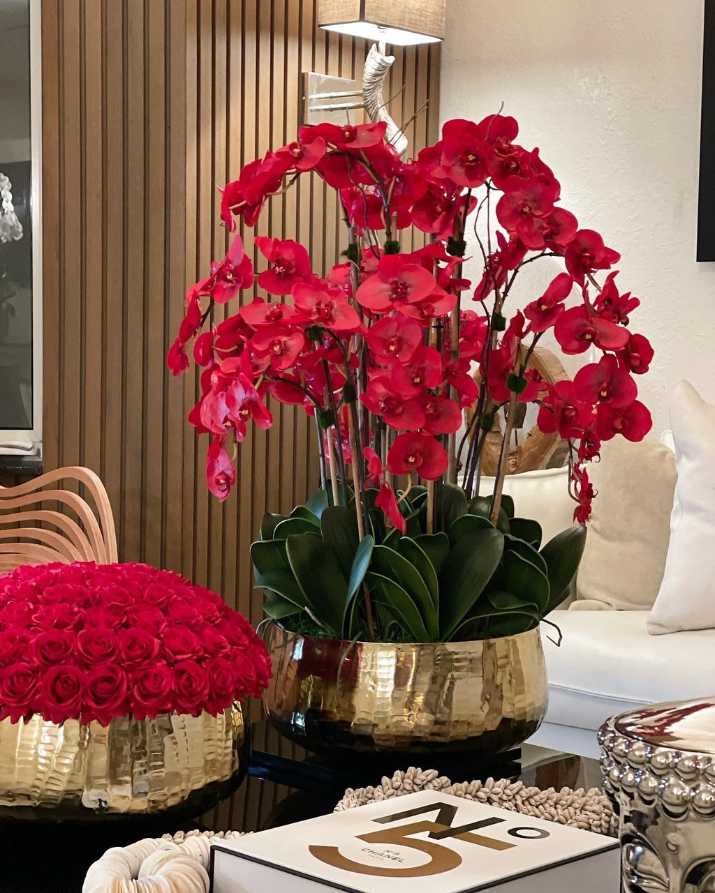 Composition florale d'orchidées Phalaenopsis rouges dans un grand pot doré