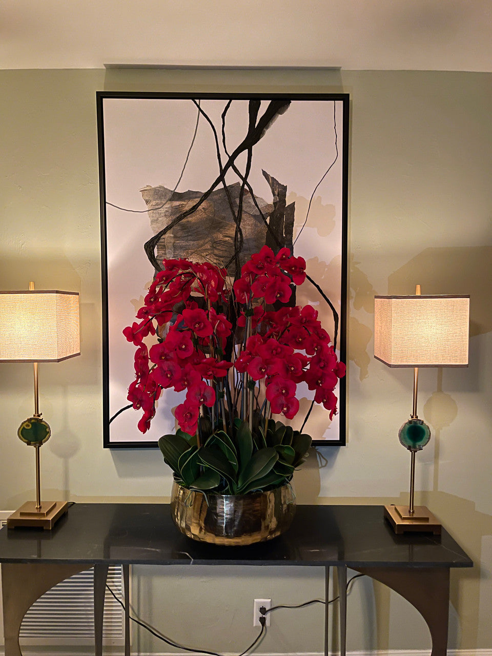 Composition florale d'orchidées Phalaenopsis rouges dans un grand pot doré