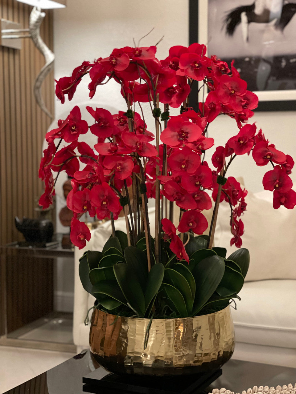Composition florale d'orchidées Phalaenopsis rouges dans un grand pot doré