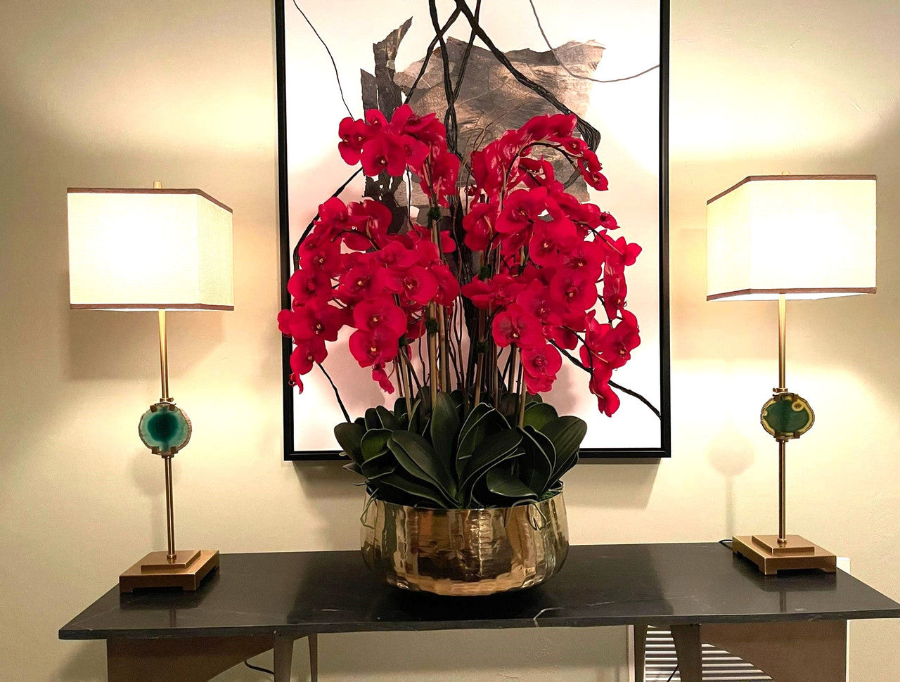 Composition florale d'orchidées Phalaenopsis rouges dans un grand pot doré