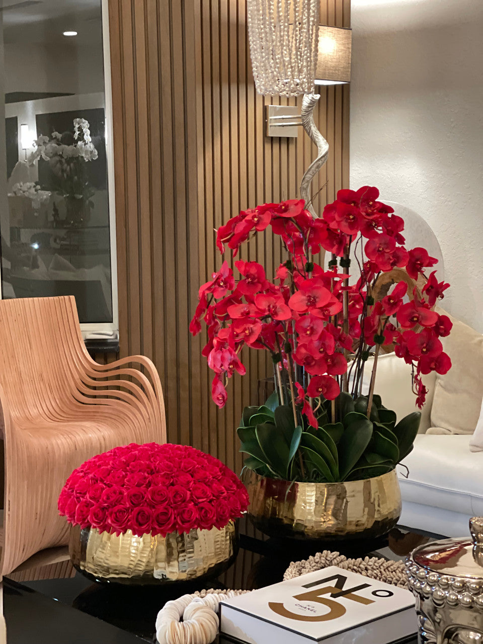 Composition florale d'orchidées Phalaenopsis rouges dans un grand pot doré
