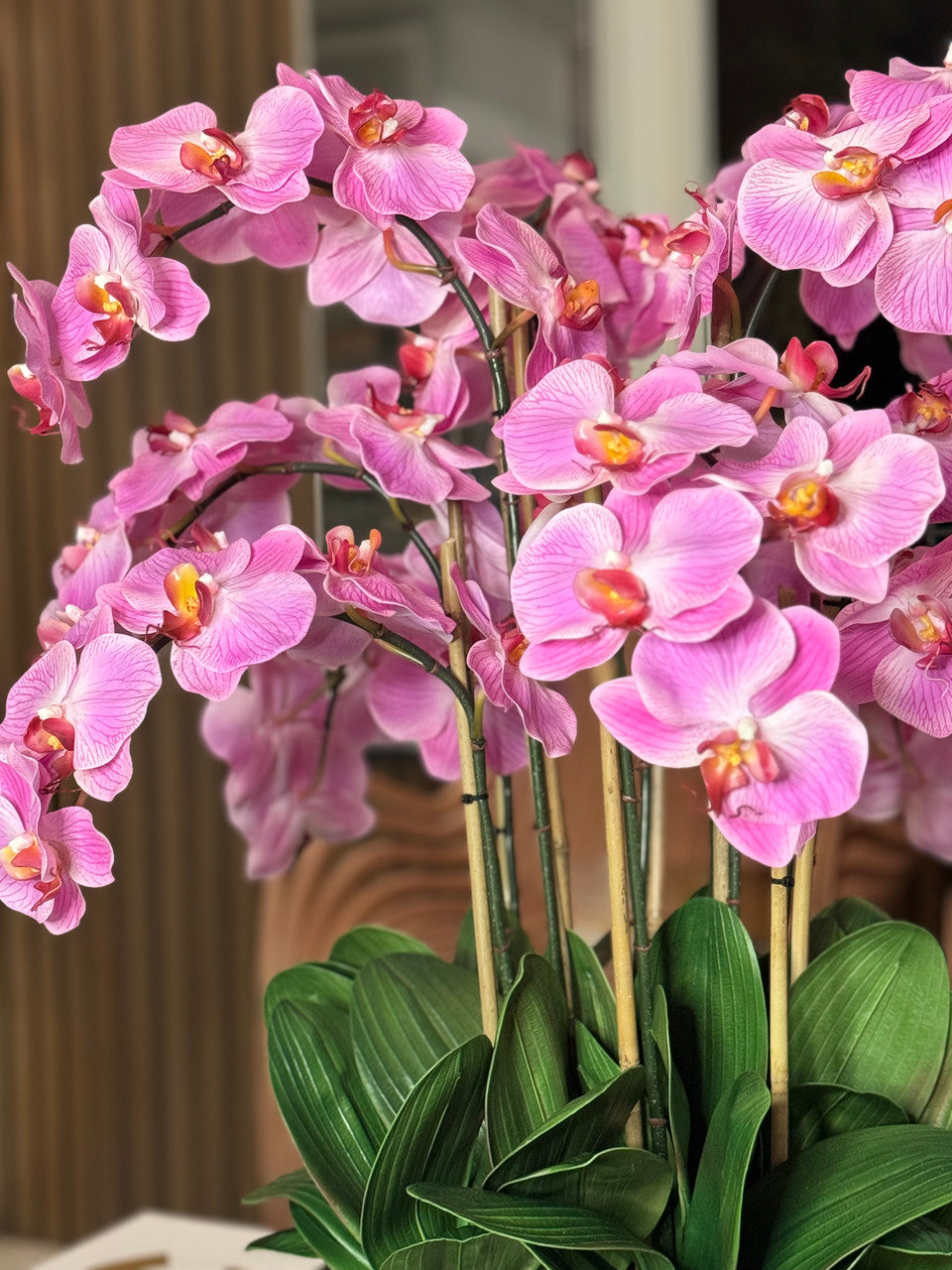 Composition florale d'orchidées Phalaenopsis rose pâle dans un pot doré moyen