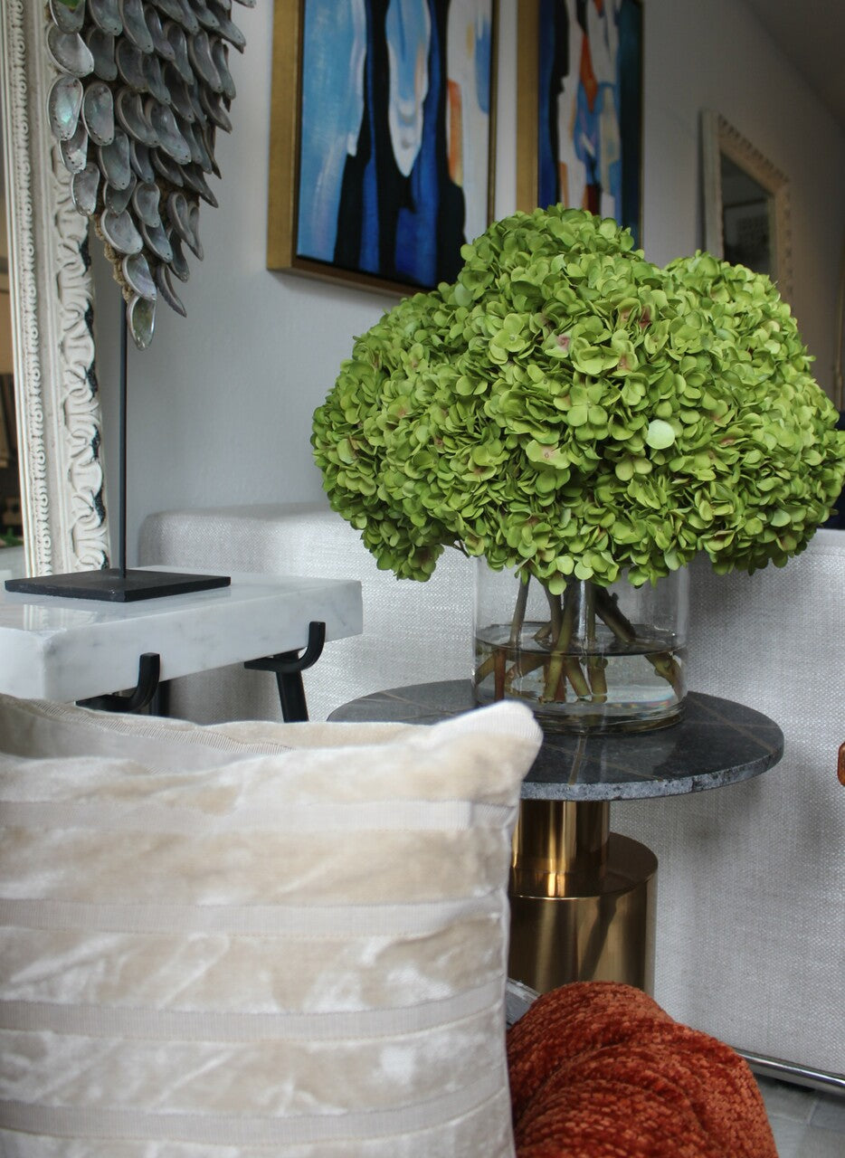 Bouquet d'hortensias verts dans un vase cylindrique en verre transparent