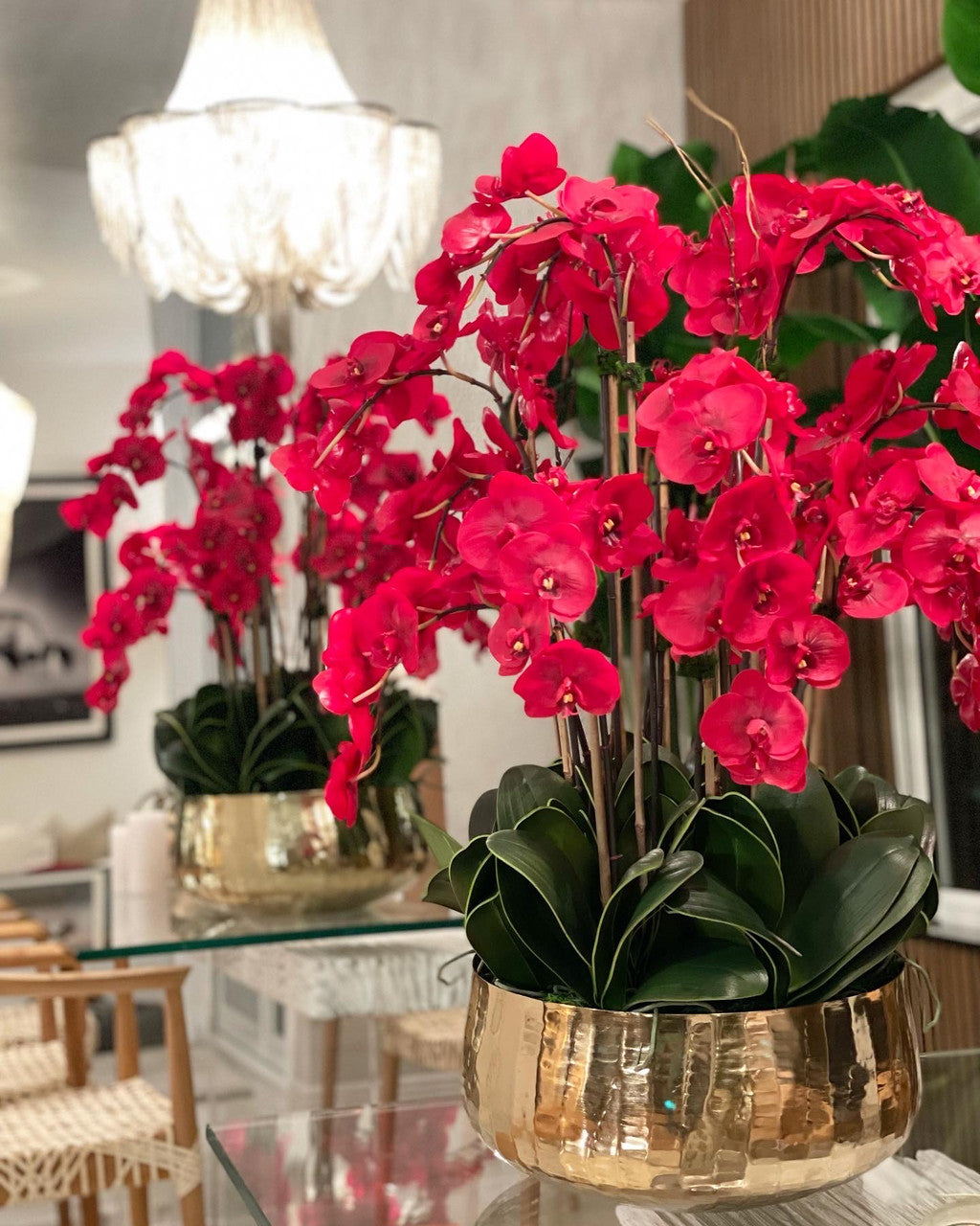 Composition florale d'orchidées Phalaenopsis rouges dans un grand pot doré