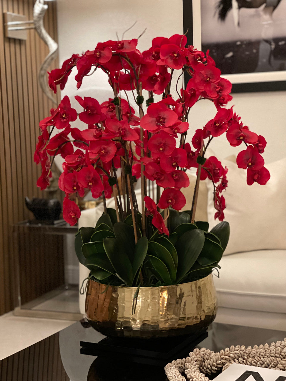 Composition florale d'orchidées Phalaenopsis rouges dans un grand pot doré